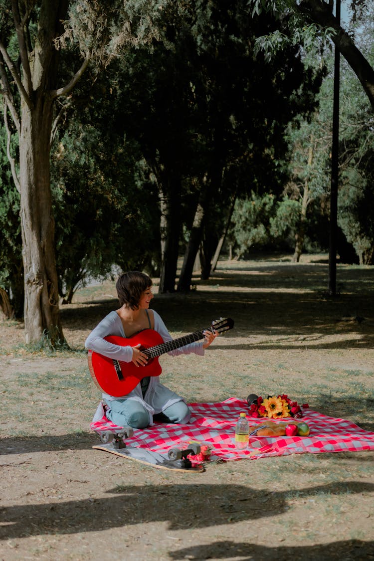 Girl Playing Guitar At Picnic 