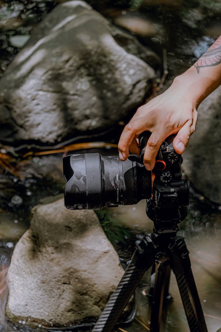 Close-up Of Man Taking Picture With Professional Camera In Nature