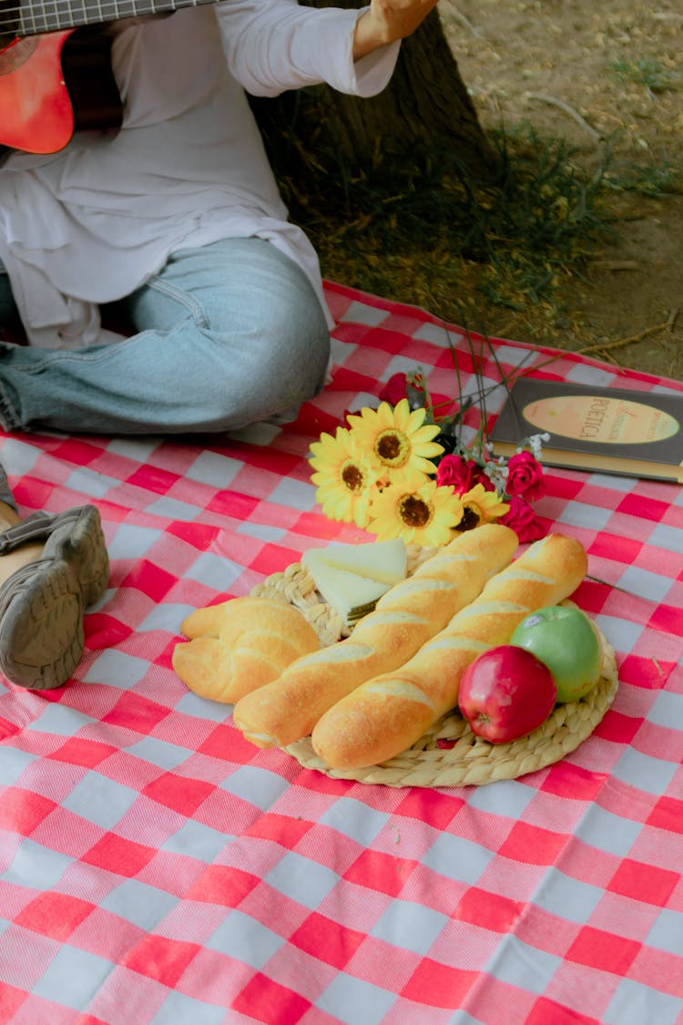 Baguettes, Apples And Other Food On A Plate On A Picnic Blanket