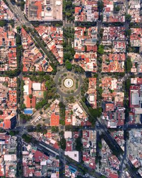 Stunning aerial view showcasing the vibrant urban grid and lush roundabout of Mexico City.