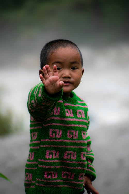 Close-Up Shot of a Cute Little Boy in Green Sweater