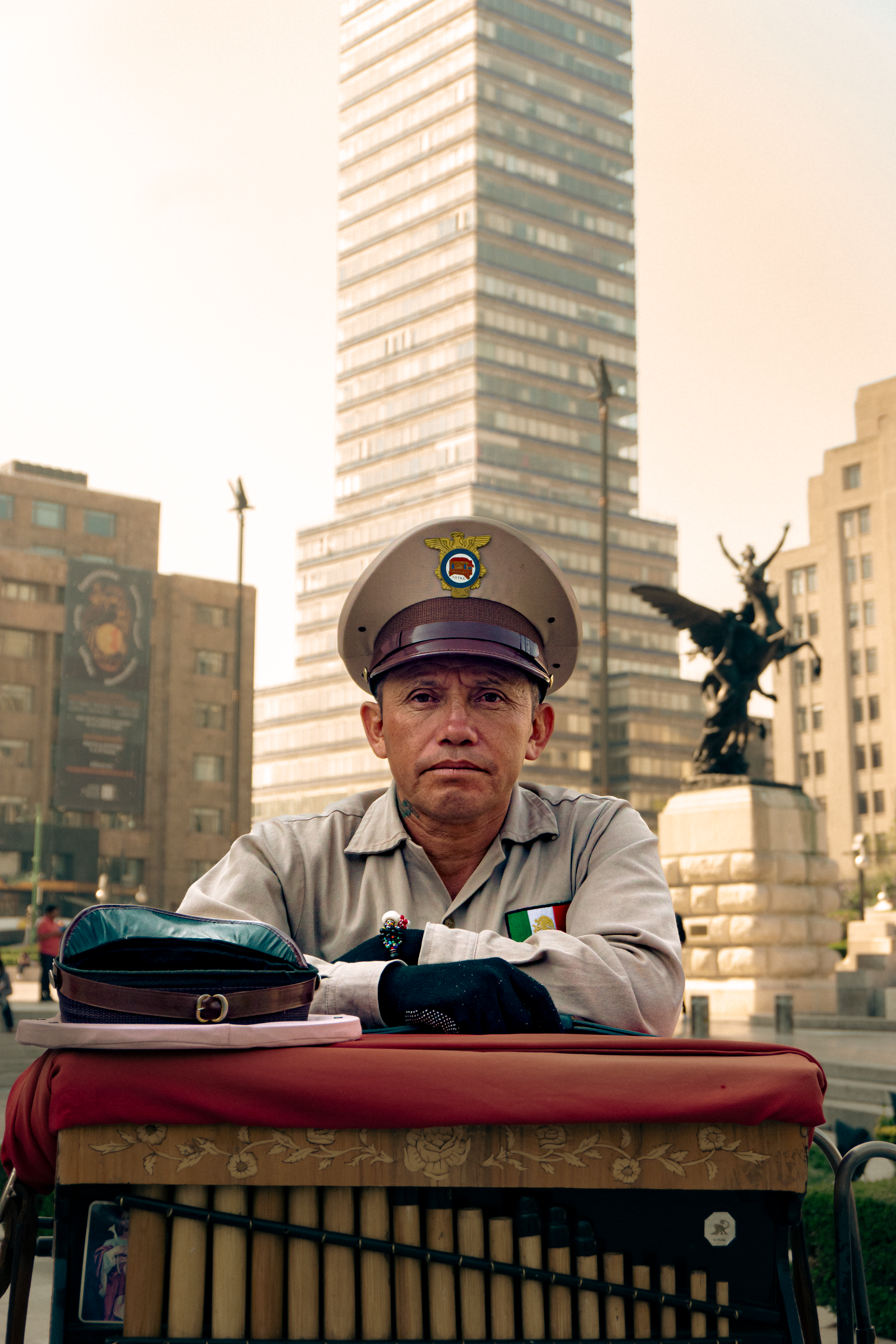 A police officer in uniform sits in front of Torre Latinoamericana, Ciudad de México.