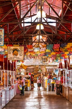 Colorful indoor market scene with stalls and shops in Tlacolula, Mexico, bustling with activity.