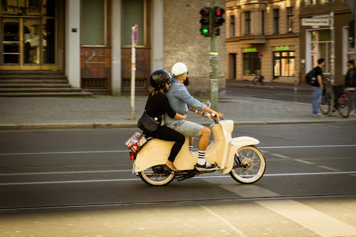 Man and Woman White Motor Scooter on Road