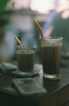 Two iced lattes with metal straws on a table, creating a cozy and relaxed atmosphere.