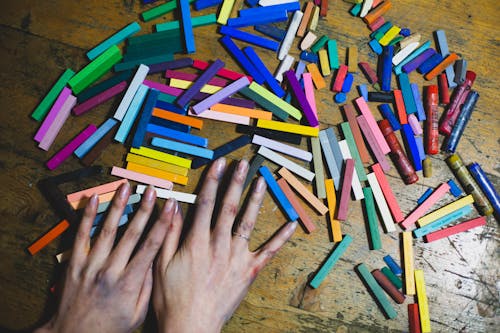 Woman Hands with Crayon Pencils on Table