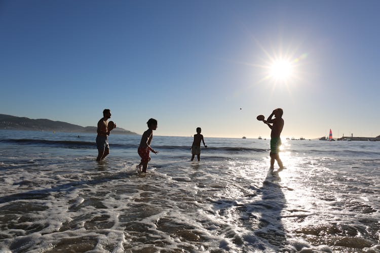 Men And Children Playing On The Beach