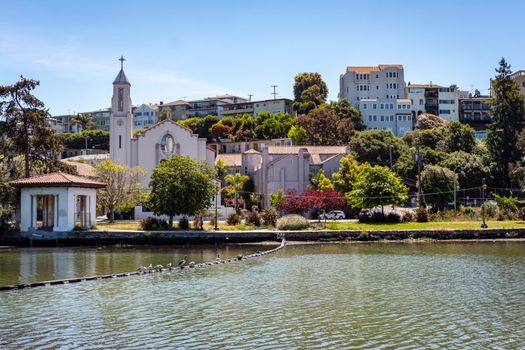 Beautiful view of Our Lady of Lourdes Church and surrounding buildings by the waterfront in Oakland, California.