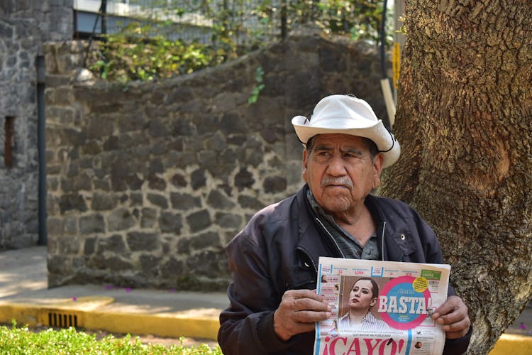 Elderly Man With White Hat Holding Newspaper