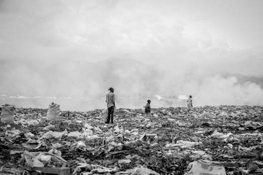 Monochrome image of people collecting waste at landfill site in Burundi.