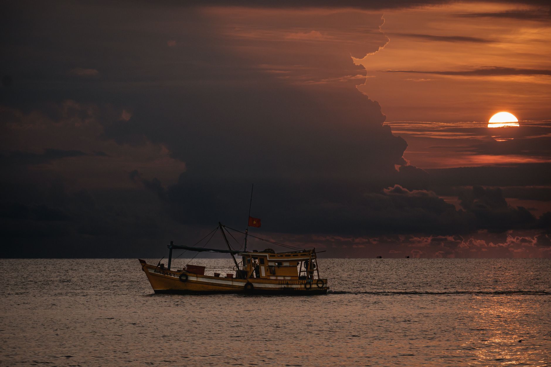A fishing boat sails on the sea at sunset, captured in Phu Quoc, Vietnam.