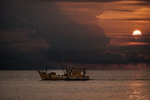 A fishing boat sails on the sea at sunset, captured in Phu Quoc, Vietnam.