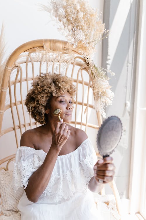 Woman with Afro Hairstyle Using Face Roller