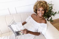 Woman in White Floral Lace Tank Top Holding White Book