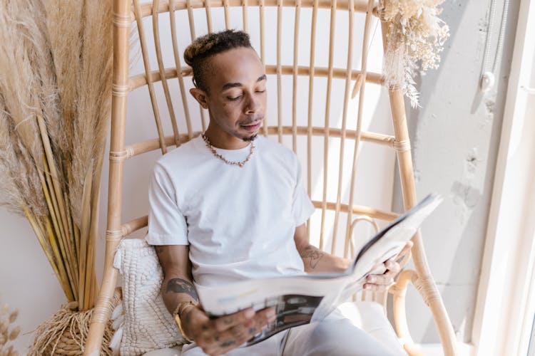 Man Reading Journal On Chair