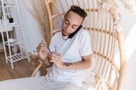 Man in White Polo Shirt Sitting on White Wicker Armchair