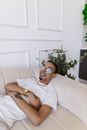 Man in White Crew Neck T-shirt Sitting on White Sofa