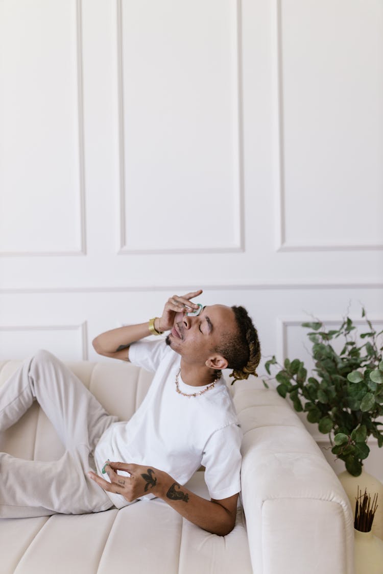 Man On Couch Putting Swab On Eye