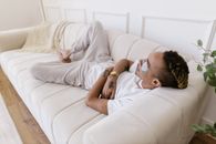 Man in White T-shirt Lying on White Couch