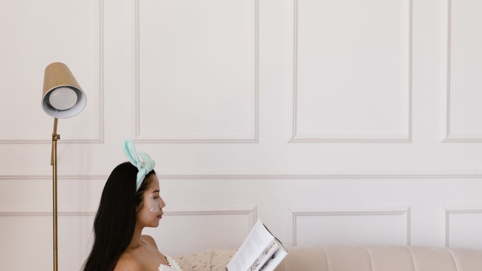 An adult reading a book on a sofa
