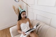 Woman in White Tube Dress Sitting on White Couch