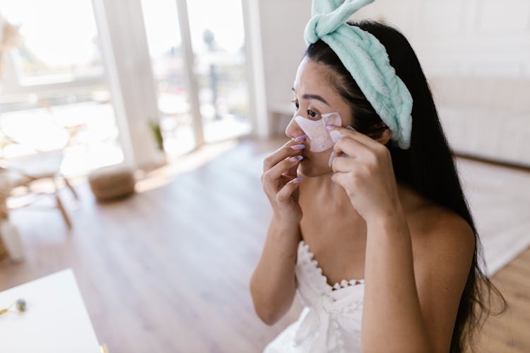 Woman While Doing Makeup On Face