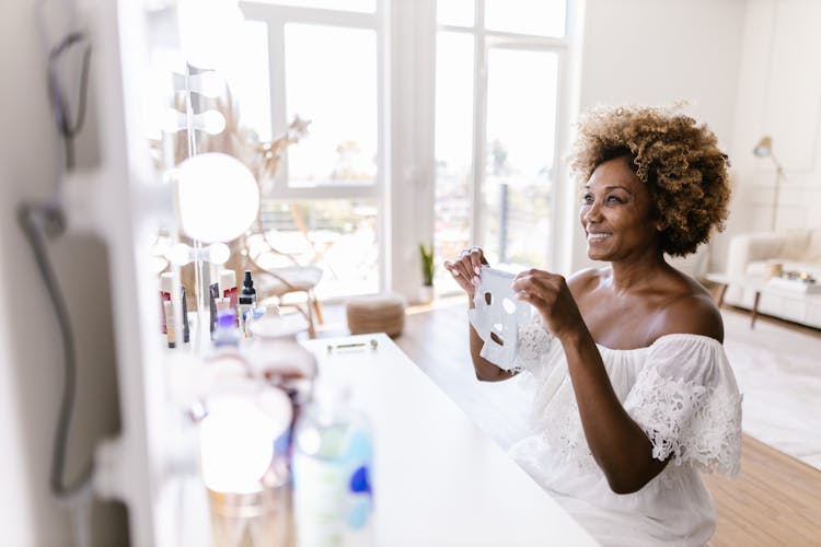 Smiling Woman Holding Facemask 