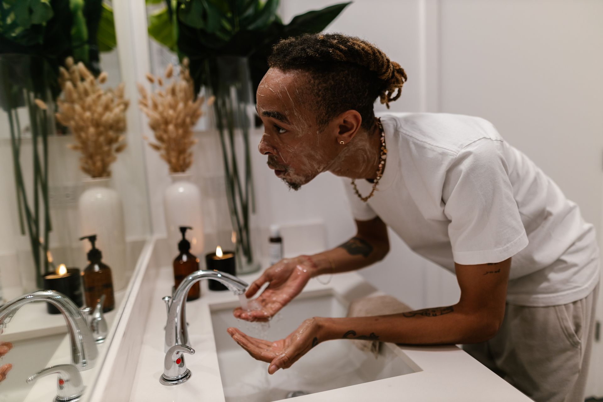 Man Cleaning Face at Bathroom Sink