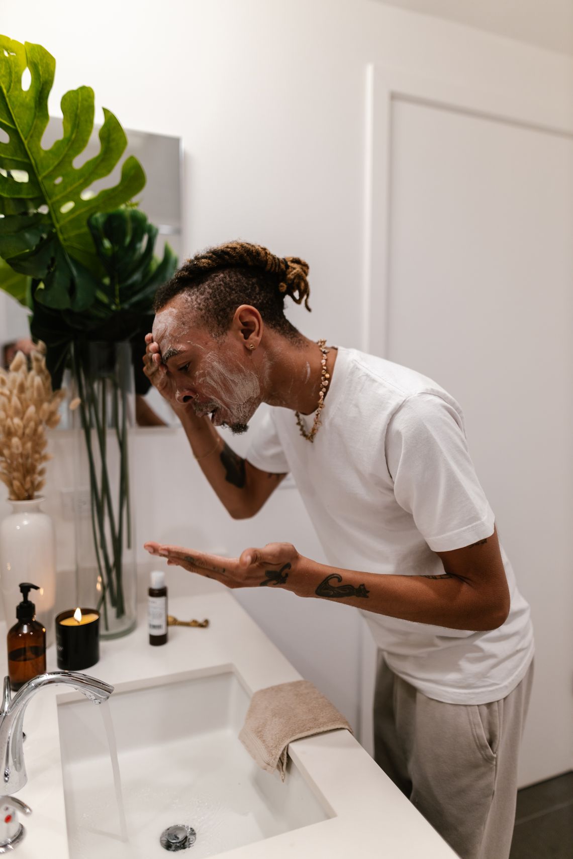 Man washing his face beside personal care products