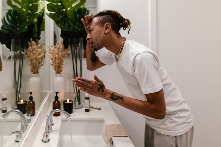 Man In Bathroom Washing Face