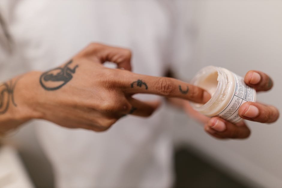 person applying aftercare cream to treated skin - removal of unwanted tattoos person applying aftercare cream to treated skin - removal of unwanted tattoos