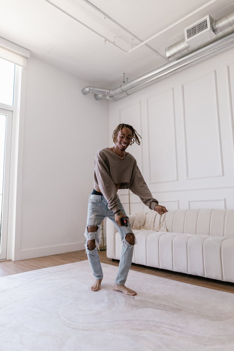 Happy Young Man Dancing In Living Room