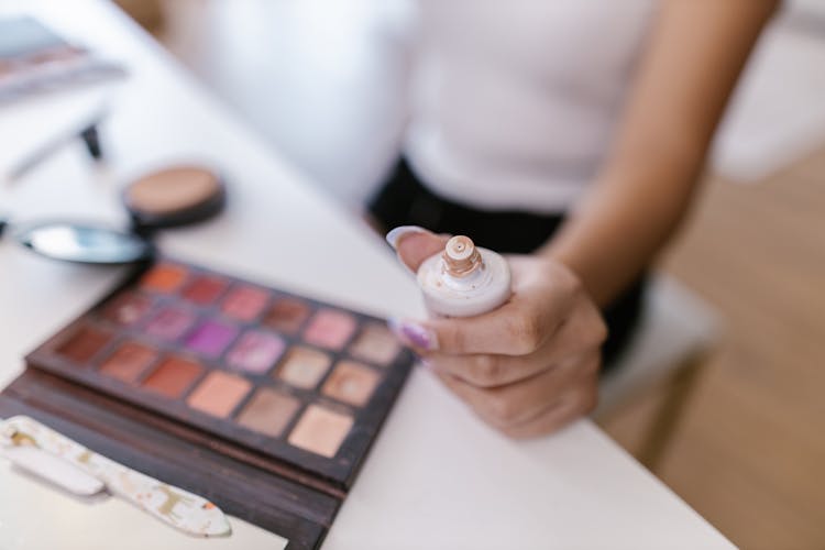 Close-up Of Makeup Artist Holding Beauty Product