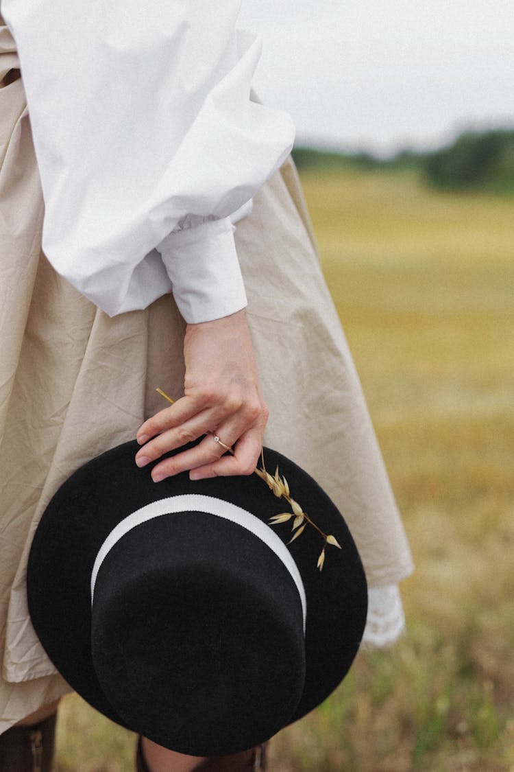 Woman Holding Hat In Hand