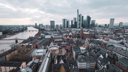 Free Captivating aerial view of Frankfurt am Main skyline with river and skyscrapers, under a moody sky. Stock Photo