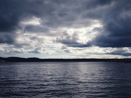 Body of Water Under Cloudy Sky