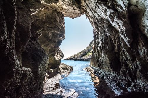 Free Explore the stunning view from a rocky cave leading to the serene ocean. Stock Photo