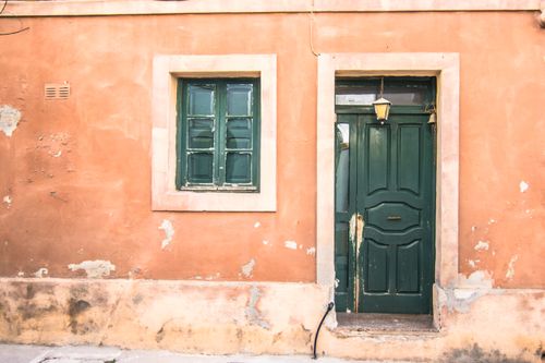 Free Old green door and window on a weathered pink wall, rustic vibe. Stock Photo