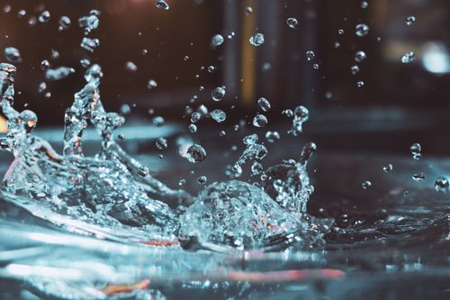 Free Captivating close-up of splashing water droplets in motion, creating a vibrant and energetic scene. Stock Photo