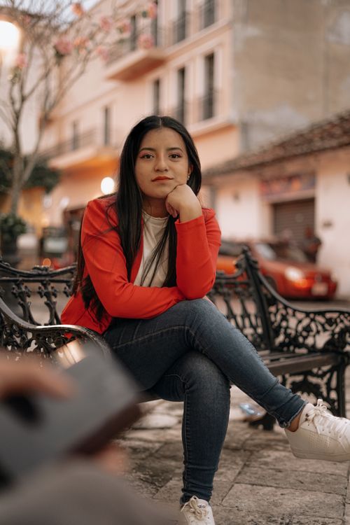 Free A young woman sits pensively on a bench in Comitán, capturing the city's vibrant atmosphere. Stock Photo