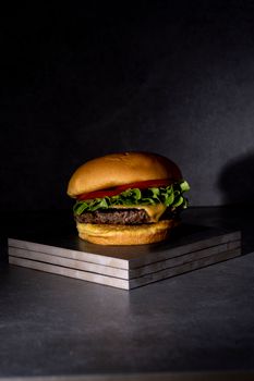 Close-up of a delicious cheeseburger on a marble platter, showcasing its fresh ingredients.