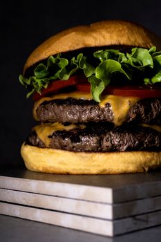 Close-up of a juicy double cheeseburger with lettuce and tomato, perfect for dinner ideas.