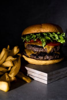 A mouthwatering double cheeseburger with crispy fries on a slate background.