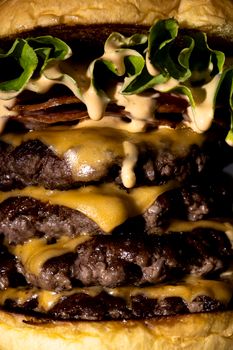 Indulge in a mouthwatering triple cheeseburger with layers of melting cheese, bacon, and fresh greens.