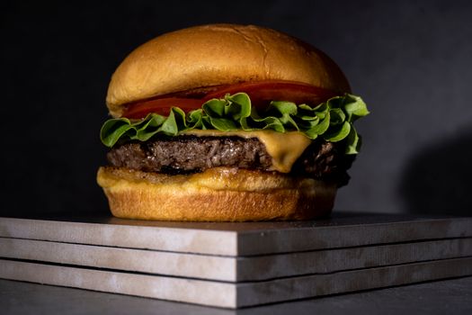 Close-up of a delicious cheeseburger with lettuce, tomato, and cheese on a bun.