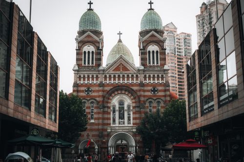 Free Saint Joseph Cathedral stands prominently against a backdrop of towering modern buildings, combining architectural styles. Stock Photo