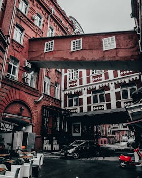 A striking view of red brick buildings connected by a bridge, showcasing urban architecture.