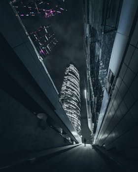 A low angle nighttime shot of illuminated skyscrapers in a modern cityscape.