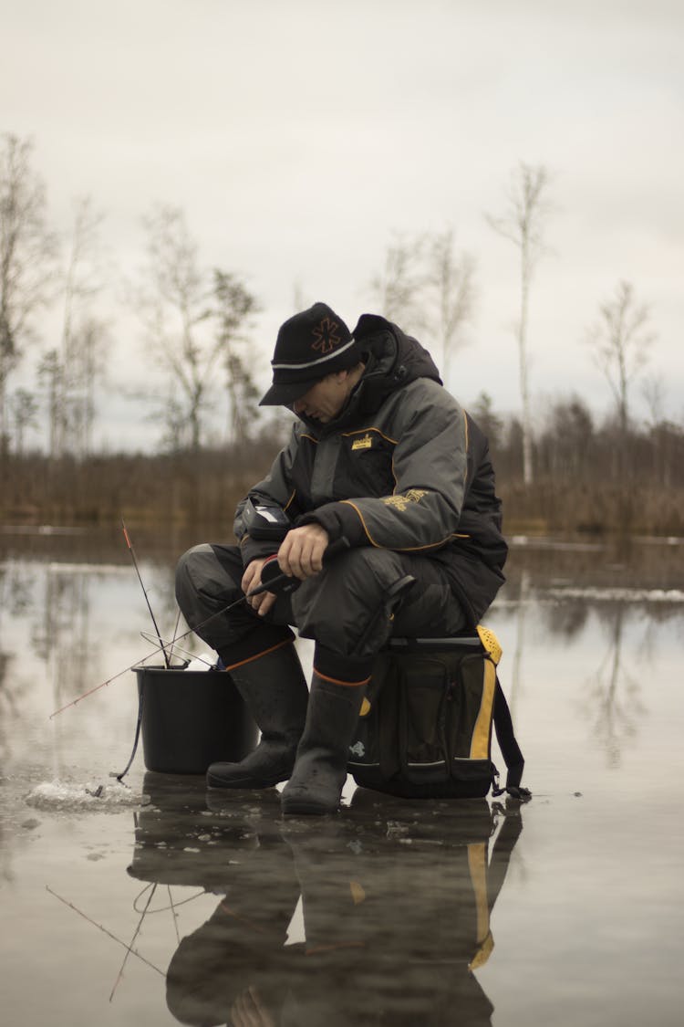 A Man Fishing On A Frozen Lake