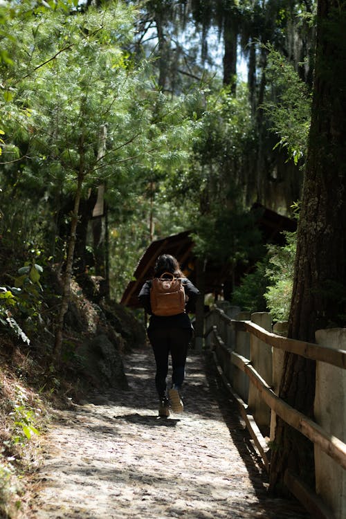 Back View of a Woman with a Brown Backpack Walking